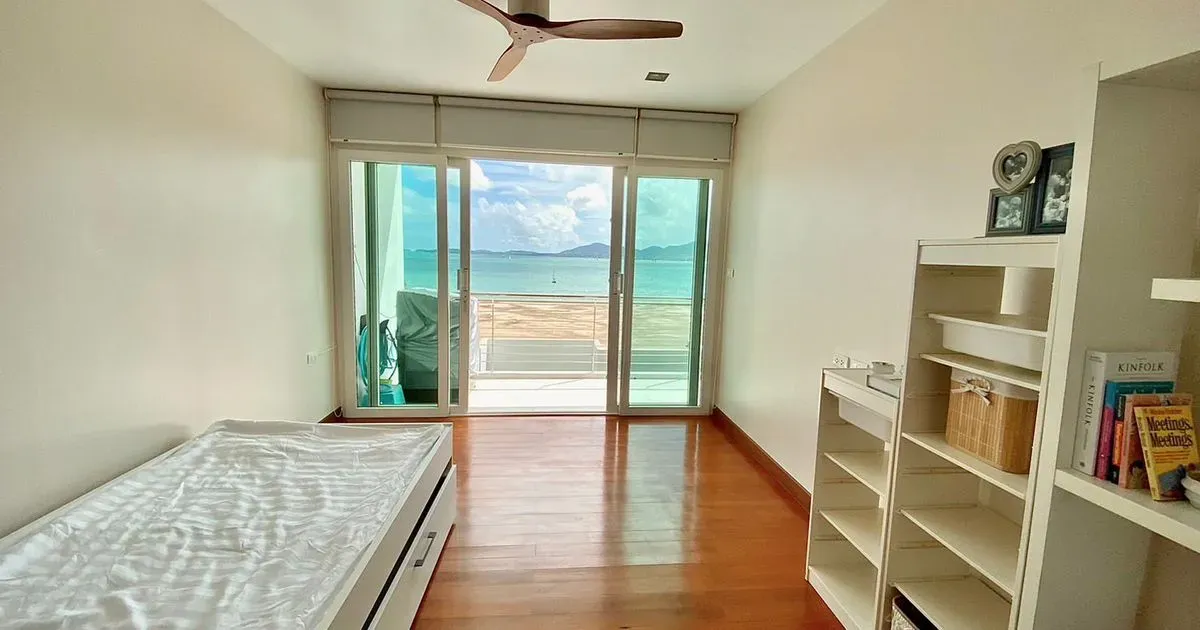 Elegant bedroom with a comfortable double bed and windows offering sea views.
